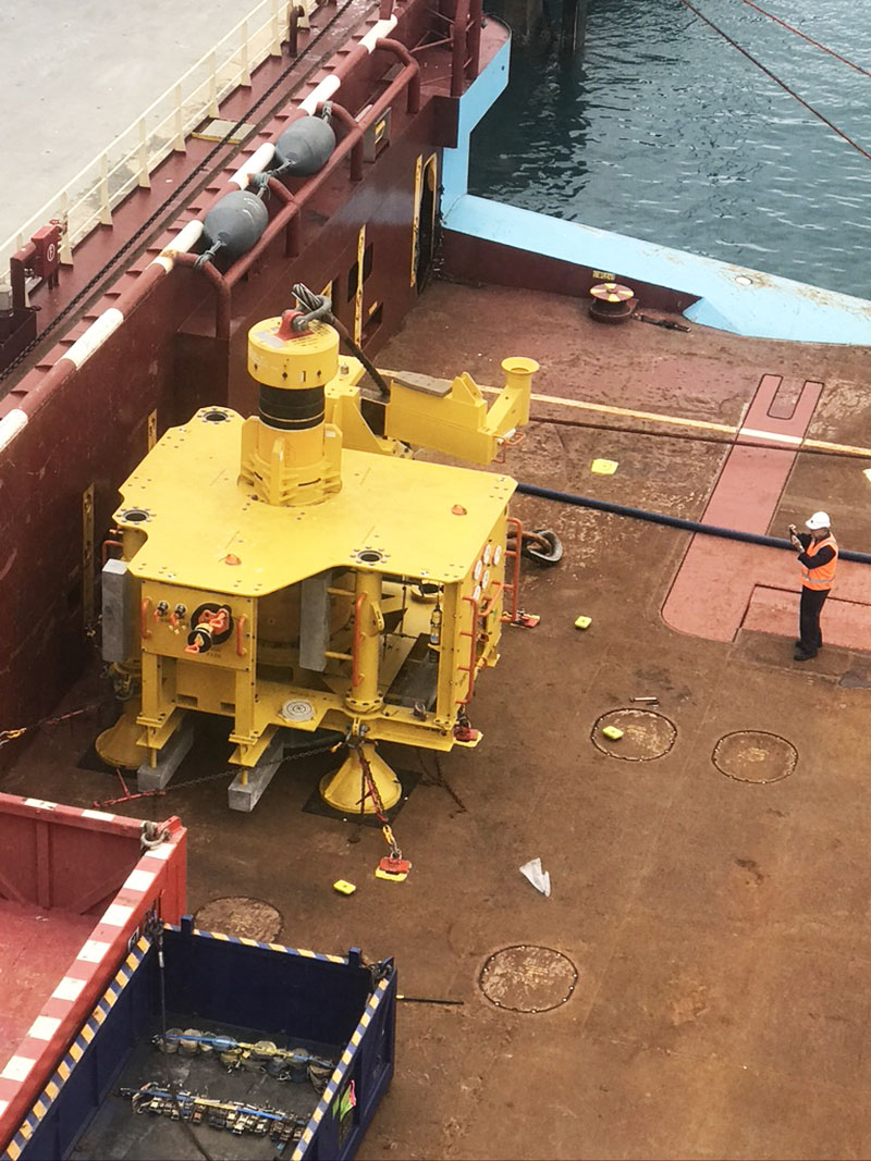 Marine crew in high-visibility PPE working a deck lift aboard a support vessel